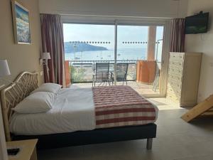 a bedroom with a bed and a view of the ocean at Hôtel La Flore in Villefranche-sur-Mer