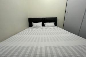 a bed with two white pillows on top of it at Hotel O Anda Kost 2 Near Lapangan Syech Yusuf Discovery in Sungguminasa