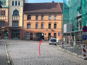 a red arrow on a street in front of a building at SweetHome - Studio Apartments, super Zentral, Parkplatz in Eisenach