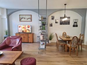 a living room with a table and chairs at NEU: Großzügige Citywohnung mit XXL Dachterrasse! in Freiberg