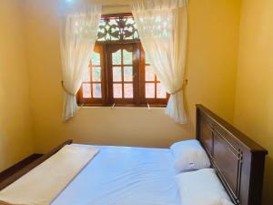 a bedroom with a bed and a window with curtains at Cliff Heaven Bungalow in Bandarawela +47 photos