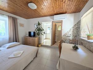 a bedroom with a bed and a television in it at Apartments Ante in Lumbarda