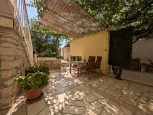 a patio with a table and chairs and a tree at Apartments Ante in Lumbarda