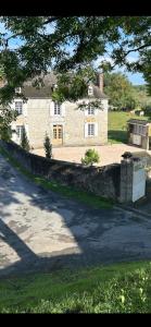 a large house with a stone wall in front of it at Maison Paisible au coeur des Pyrénées in Igon