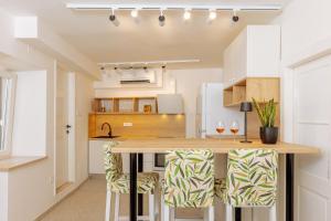 a kitchen with a wooden counter and stools at Old Charming House in Lastovo