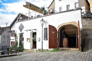 a white building with an archway on a street at Doppelzimmer in der Altstadt in Nürtingen