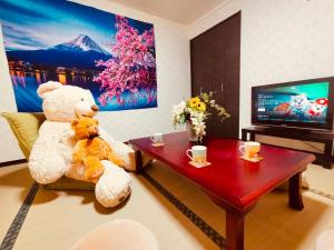 a large teddy bear sitting on a chair in a living room at SECRET BASE Station Side in Osaka