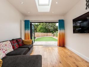 シドカップにあるPass the Keys 4 Bed house Parking 5 mins Sidcup Stationのソファと大きな窓のあるリビングルーム