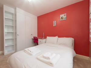 シドカップにあるPass the Keys 4 Bed house Parking 5 mins Sidcup Stationの赤い壁のベッドルーム1室(白いベッド1台付)