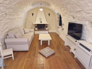 a living room with a white couch and a tv at Krialianika House in Areopoli