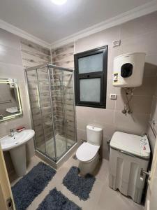 une salle de bains avec douche, toilettes et lavabo dans l'établissement Celia, à Madīnat al Amal