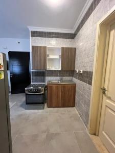 une cuisine avec une cuisinière et un évier dans l'établissement Celia, à Madīnat al Amal