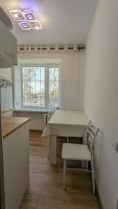 a kitchen with a table and chairs in a room at Cozy apartment in the city center of Karakol in Karakol