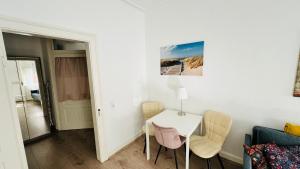 un salon avec une table et des chaises blanches dans l'établissement Gemütliche Altbauwohnung in Stuttgart Ostendplatz, à Stuttgart 13 autres photos