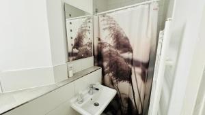 une salle de bain avec un lavabo et un miroir dans l'établissement Gemütliche Altbauwohnung in Stuttgart Ostendplatz, à Stuttgart