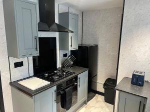 a kitchen with white cabinets and a stove top oven at Modern 2 bedroom apartment in Nantwich