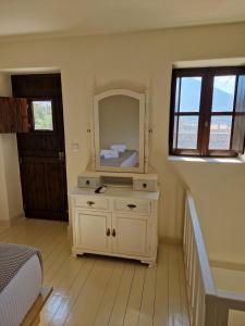 a bedroom with a white dresser with a mirror at Krialianika House 2 in Areopolis +25 photos