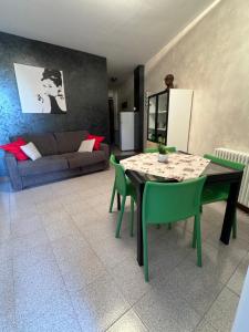 a living room with a table and green chairs at fior di loto in Desenzano del Garda +2 photos