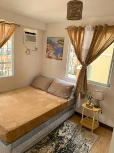 a bedroom with a bed and two windows at The Boho Bungalow in Sasabayou