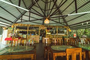 een restaurant met houten tafels en stoelen en een plafond bij Trang An Royal Bungalow in Ninh Binh