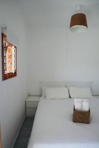 Un dormitorio con una cama blanca con toallas. en Bonaire Pura Vida, en Puerto Rico de Gran Canaria