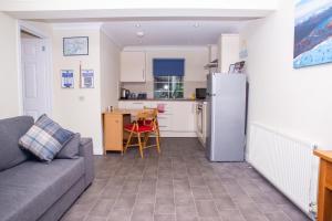 a living room with a couch and a kitchen at Braeside Guest House, Loch Lomond in Drymen