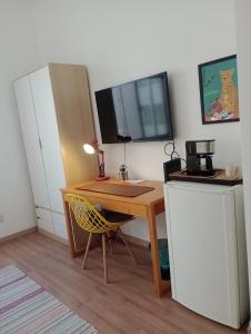 un escritorio con televisión y un escritorio con silla en Ipanema prudente 211, en Río de Janeiro