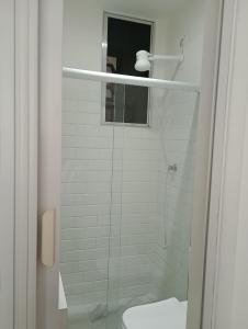 Un baño blanco con ducha y WC. en Ipanema prudente 211, en Río de Janeiro