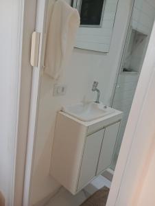 Un baño blanco con lavabo y espejo. en Ipanema prudente 211, en Río de Janeiro