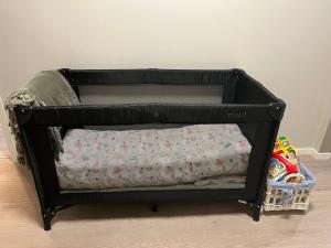 a black crib with a blanket in a room at Rom til leie i Tromsø - nært alt - flott standard in Tromsø