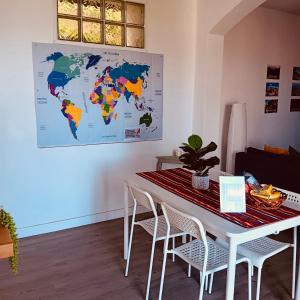 a white table with chairs and a world map on the wall at Casa D'Avó Filó in Funchal +19 photos