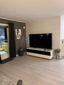 a large living room with a large flat screen tv at Rom til leie i Tromsø - nært alt - flott standard in Tromsø