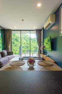 a living room with a couch and a table at The Valley at Sunshine, Panoramic in Pak Chong
