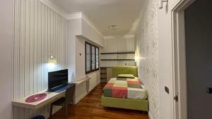 a bedroom with a bed and a desk with a television at Leonardo rooms in Avellino