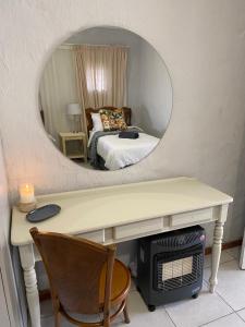 a room with a desk with a mirror and a bed at Fynbos cottage in Bethlehem