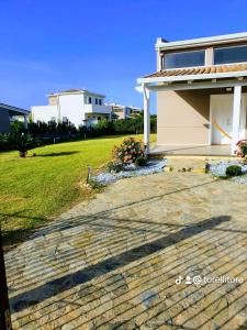 a house with a brick walkway next to a yard at Villa Charme & Relax in Campofelice di Roccella