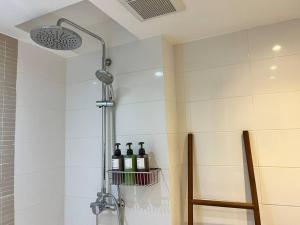 a shower with bottles of wine in a bathroom at Nimmala - Home Studio at Nimman in Chiang Mai +16 photos