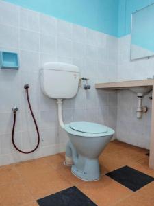 a bathroom with a toilet with a hose at Hotel Tiara in Cukai