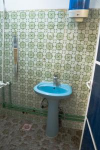a bathroom with a blue sink and a phone at Blue Wave Home in Al Bustān +22 photos