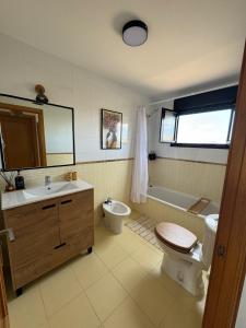 a bathroom with a sink and a toilet and a tub at Villa Miraki Fuerteventura Surf Relax in La Oliva
