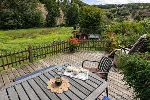 une table et des chaises sur une terrasse en bois dans l'établissement Ferienwohnung Am Quellental, à Meinerzhagen