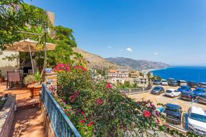 a balcony with flowers and a view of the ocean at Amaurusa Boutique Hotel in Taormina
