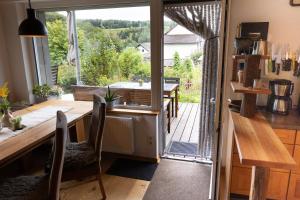une cuisine avec une table et des chaises ainsi qu'une grande fenêtre dans l'établissement Ferienwohnung Am Quellental, à Meinerzhagen