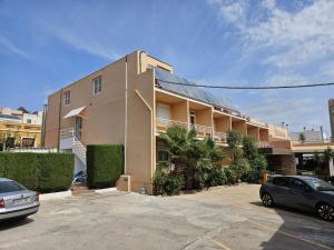 a building with a car parked in a parking lot at Eco Avenida Hotel & Parking in Benicàssim