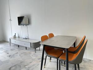 une salle à manger avec une table et des chaises et une télévision dans l'établissement Deluxe room marina View Villas, à Port Dickson 14 autres photos