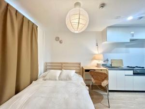 a bedroom with a bed and a desk and a kitchen at Shinjuku YC Hostel in Tokyo
