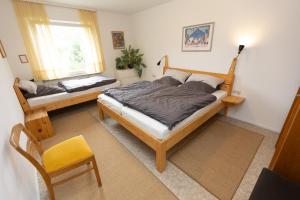 une chambre avec deux lits et une chaise et une fenêtre dans l'établissement Ferienwohnung Am Quellental, à Meinerzhagen