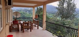 a balcony with a table and chairs and a view at სახლი ბუნებაში House in nature in Ts'ikhisdziri