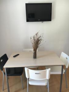 a dining room table with a vase of flowers on it at Apartments Jakišnica in Jakišnica