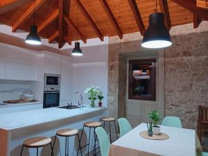 a kitchen with a table and chairs and a kitchen with white counters at Casa das Cazolas in Oia